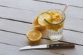 Homemade detox fortified water, sliced lemon and water in glass, knife on white wooden table, copy space Royalty Free Stock Photo