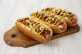 Homemade detroit style chili dog on a rustic wooden board on a white wooden background, side view. Close-up Royalty Free Stock Photo