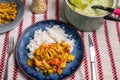 Homemade dining, luch or dinner. Asian food turkey meat with vegetable and rice on blue plate, pea soup in pot on table Royalty Free Stock Photo