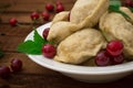 Homemade dumplings with cherries. Wooden rustic background. Close-up. Top view