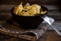 Homemade dumplings in clay pots on the kitchen table, fork and folklor napkin. Royalty Free Stock Photo