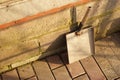 Homemade dustpan is standing against the wall of the house on the tiled floor of the courtyard Royalty Free Stock Photo