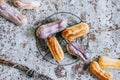 Homemade eclairs in colored glaze on a metal