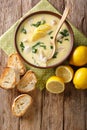 Homemade egg lemon soup with chicken and orzo pasta close-up in a bowl. Vertical top view Royalty Free Stock Photo