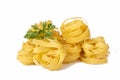 Homemade egg pasta tagliatelle. Raw nest noodles, uncooked ribbon fettuccine, dry long rolled macaroni isolated on white Royalty Free Stock Photo