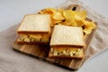 Homemade Egg Salad Sandwich with Potato Chips on a wooden board, side view Royalty Free Stock Photo