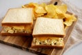 Homemade Egg Salad Sandwich with Potato Chips on a wooden board, side view Royalty Free Stock Photo