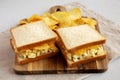 Homemade Egg Salad Sandwich with Potato Chips on a wooden board, side view Royalty Free Stock Photo