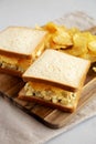 Homemade Egg Salad Sandwich with Potato Chips on a wooden board, side view Royalty Free Stock Photo