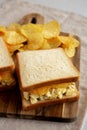 Homemade Egg Salad Sandwich with Potato Chips on a wooden board, side view Royalty Free Stock Photo