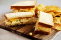 Homemade Egg Salad Sandwich with Potato Chips on a wooden board, side view. Close-up Royalty Free Stock Photo