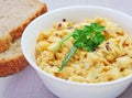 Homemade egg salad in white bowl with bread slices Royalty Free Stock Photo