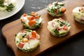Homemade Egg White Breakfast Cups with Spinach and Tomato on a rustic wooden board on a black surface, side view