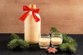 Homemade eggnog in bottle and two glasses with Christmas cookies