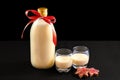 Homemade eggnog in bottle and two glasses with Christmas cookies