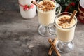 Homemade eggnog with cinnamon on wooden table. Typical Christmas dessert.