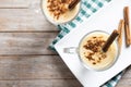 Homemade eggnog with cinnamon on wooden table. Typical Christmas dessert.