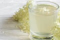 Homemade elder flower syrup with flowers on white wooden table. healthy herbal drink