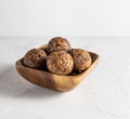Homemade energy balls with dates, prunes, almonds. Healthy sweet food. Energy balls in a wooden bowl on a white background