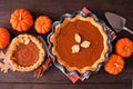 Homemade fall pumpkin pies. Table scene on dark wood.