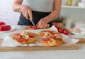 Pimped up baked frozen pizza is prepared by a woman in the kitchen Royalty Free Stock Photo