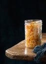 Homemade fermented cabbage kimchi sauerkraut, sour glass jars over rustic kitchen table, dark background, copy space Royalty Free Stock Photo