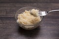 Homemade Fermented Celeriac Salad on Fork Above Glass Bowl. Preserved Vegetable On Table