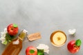 Homemade fermented kombucha in a bottle and in a glass with apples on a light gray stone background.