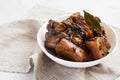 Homemade Filipino Adobo Pork in a white bowl, side view.