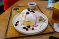 Homemade Fluffy Japanese Pancakes with berry sauce and ice cream topping on a white plate