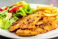 Homemade food concept. Chicken breast steak with black pepper served with salad and french fries in a white dish. High protein Royalty Free Stock Photo