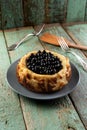 Homemade forest bluebery cheesecake on the old painted wood with wooden spatula