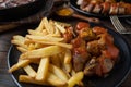 Homemade french fries with german curry sausage on rustic table Royalty Free Stock Photo