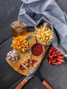 Homemade French Fries, Onions, Garlic, Smoked Sausages, Fork and Spoon on Dark Wooden Table. Top view