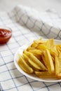 Homemade french fries with sour-sweet sauce on a white plate, side view. Close-up Royalty Free Stock Photo