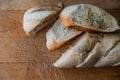 Homemade fresh Baguette with garlic butter and aromatic herbs on old rustic wooden table. Top view food photography Royalty Free Stock Photo