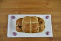 Freshly baked hot cross buns on a napkin with Easter egg decorations