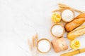 Homemade fresh bread and pasta near flour in bowl and wheat ears on white stone background top view copy space