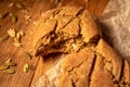 Homemade fresh bread and wheat grains on parchment paper the wooden table Royalty Free Stock Photo
