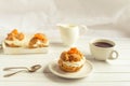 Homemade fresh cream puff with whipped cream and apricots, cup of coffee and milk jug. Royalty Free Stock Photo