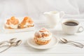 Homemade fresh cream puff with whipped cream and apricots, cup of coffee and milk jug. Toning. Royalty Free Stock Photo