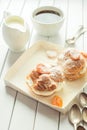 Homemade fresh cream puff with whipped cream and apricots powdered sugar on top, cup of coffee and milk jug. Toning. Royalty Free Stock Photo