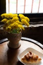 Homemade fresh croissant serves on white plate for the client`s morning breakfast on wooden table near the window with yellow Royalty Free Stock Photo