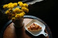 Homemade fresh croissant serves on white plate for the client`s morning breakfast on wooden table near the window with yellow Royalty Free Stock Photo