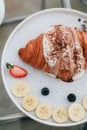 Homemade fresh croissants with sweet topping banana, cream and strawberry. Royalty Free Stock Photo