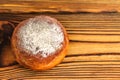 Homemade fresh donut sprinkled with powdered sugar on wooden table, top view. with space for text