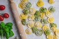 Homemade fresh Italian ravioli pasta on white wood table with flour, basil, tomatoes,background,top view Royalty Free Stock Photo