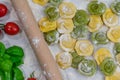 Homemade fresh Italian ravioli pasta on white wood table with flour, basil, tomatoes,background,top view Royalty Free Stock Photo