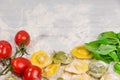 Homemade fresh Italian ravioli pasta on white wood table with flour, basil, tomatoes,background,top view Royalty Free Stock Photo