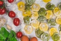 Homemade fresh Italian ravioli pasta on white wood table with flour, basil, tomatoes,background,top view Royalty Free Stock Photo